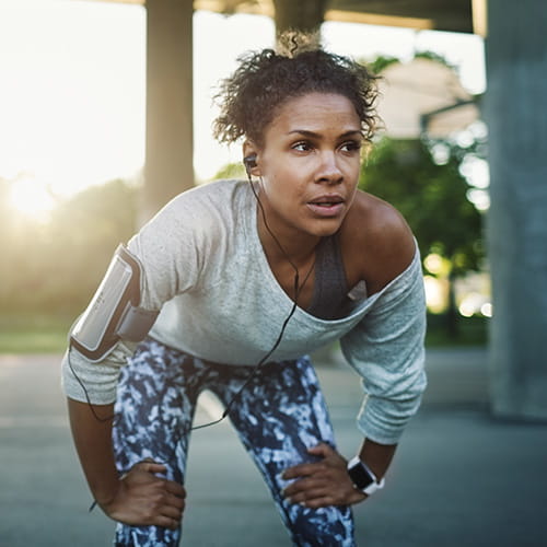 Woman resting on knees after working out